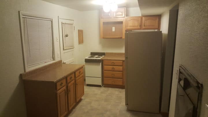 A kitchen with wooden cabinets , a refrigerator , stove and dishwasher.