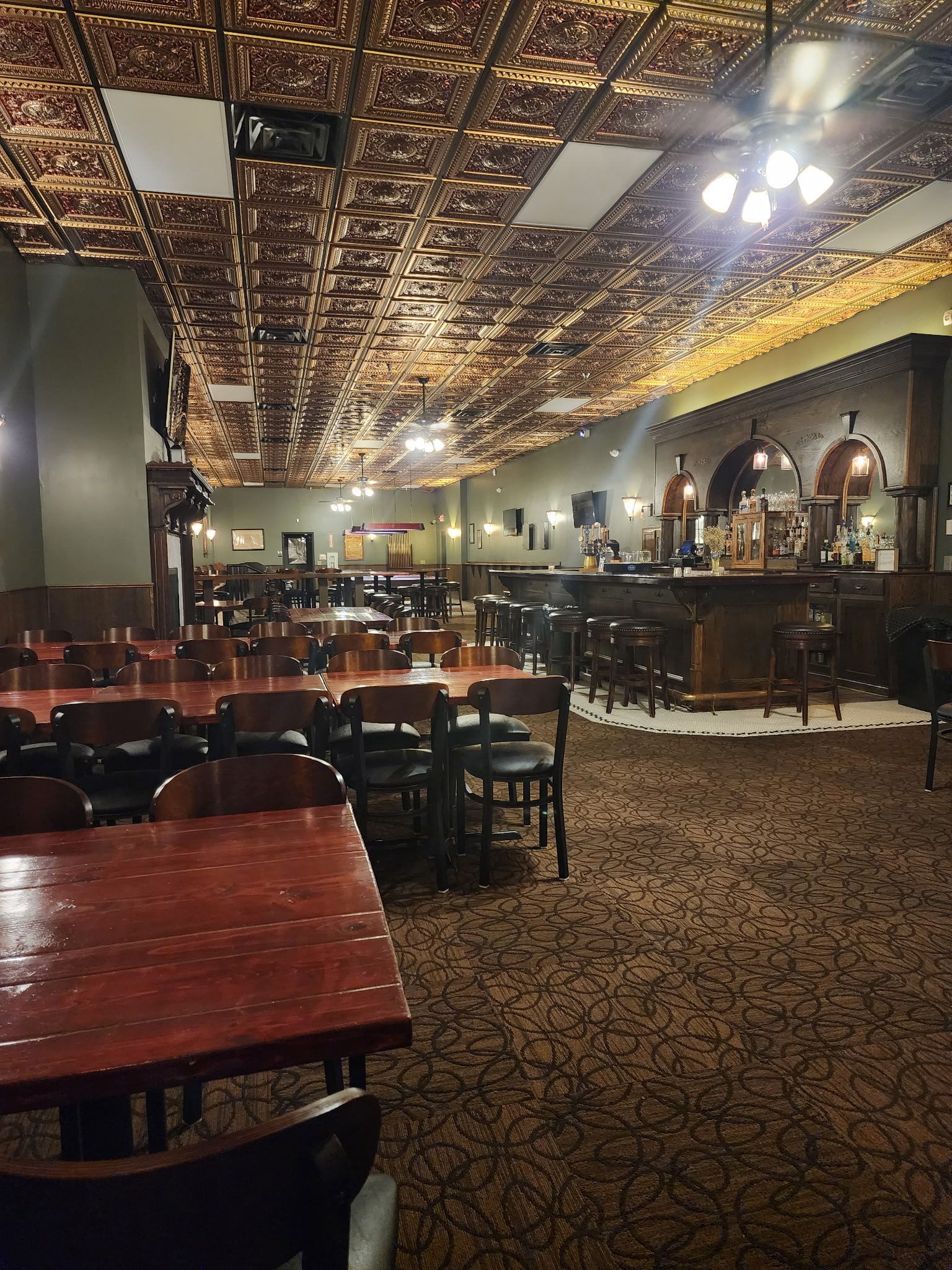 A restaurant with tables and chairs and a bar.