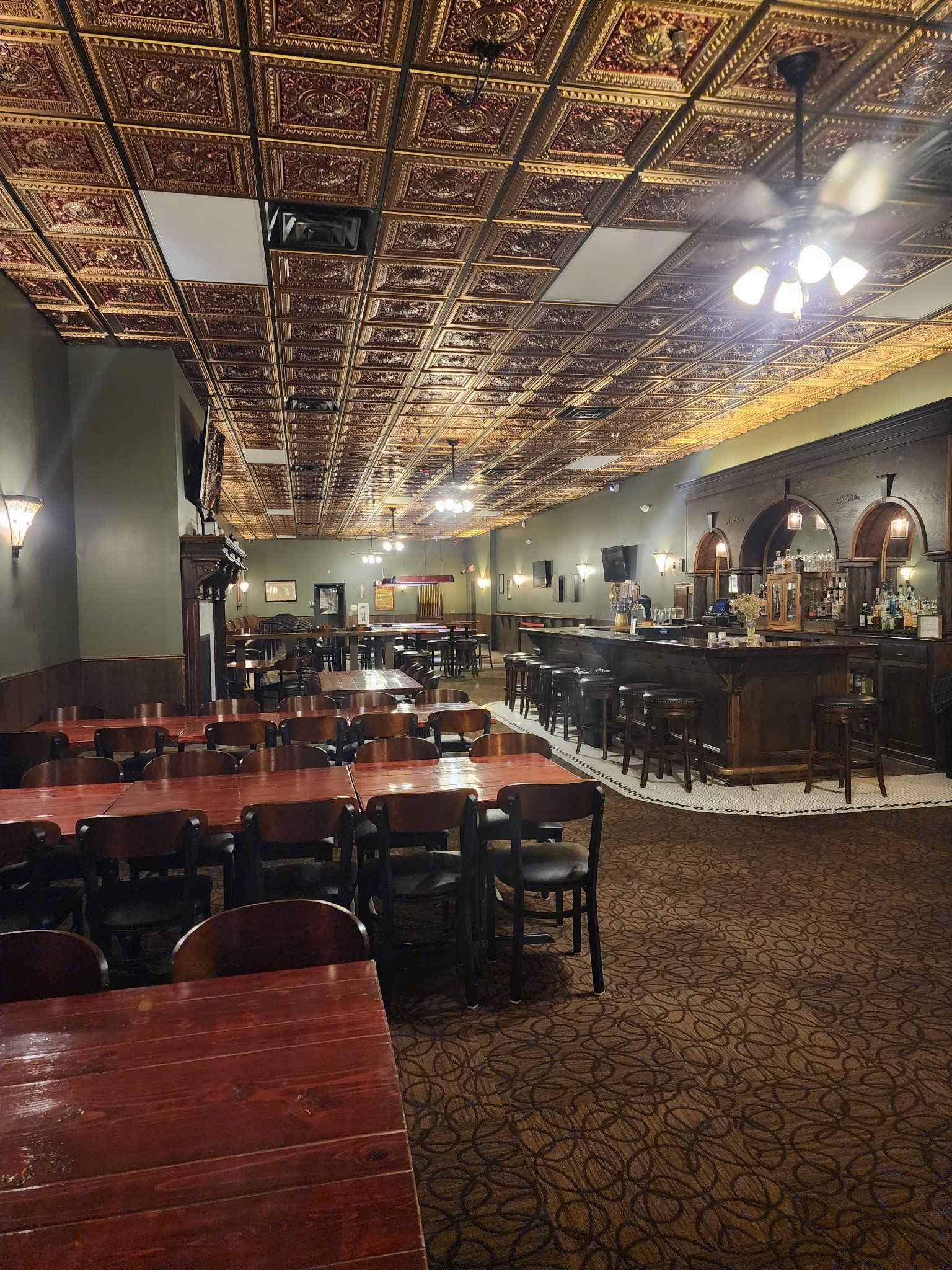 A large dining room with tables and chairs and a bar.