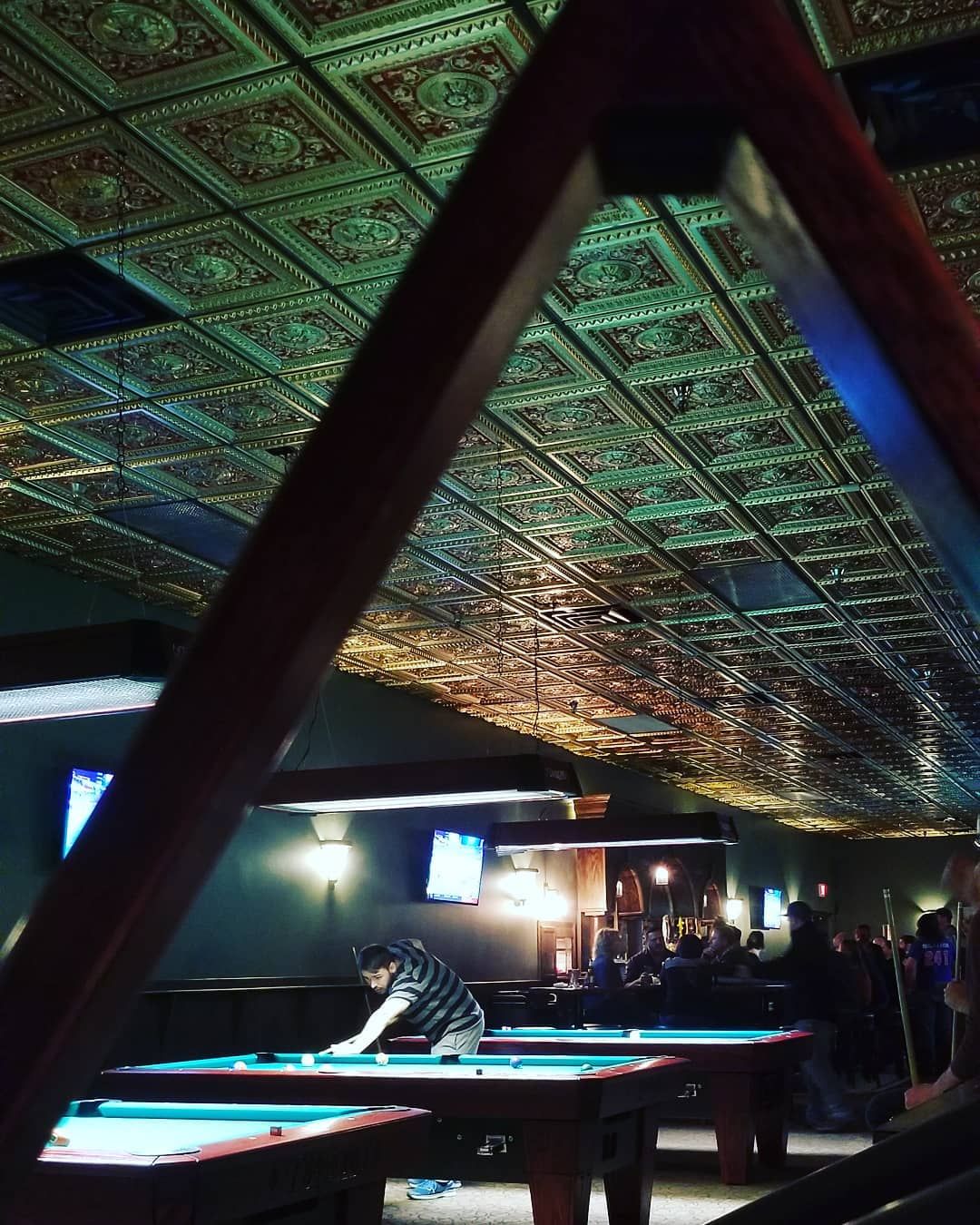 A man is playing pool in a pool hall