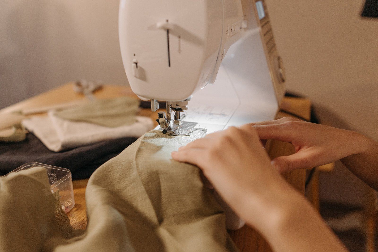 A person is using a sewing machine to sew a piece of fabric.