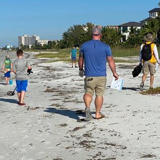 A group of people are walking on the beach