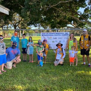 A group of people are posing for a picture in a park.