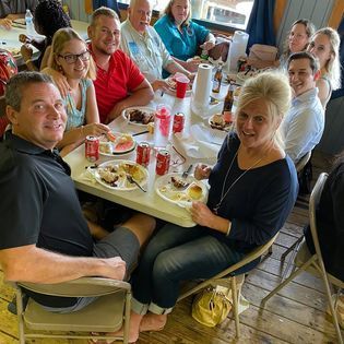 A group of people are sitting at a table eating food.