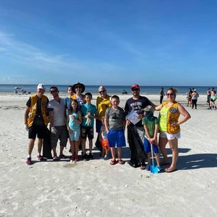 A group of people are posing for a picture on the beach.
