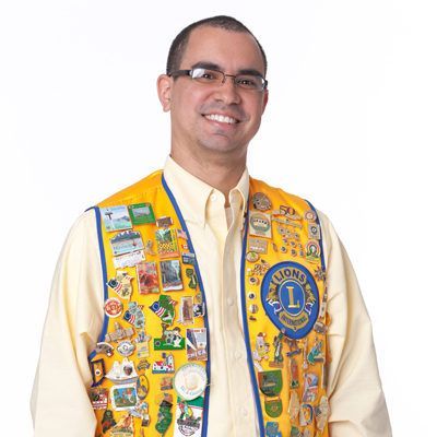 A man wearing a yellow vest that says lions on it