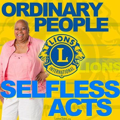 A woman in a pink shirt stands in front of a lion 's club logo