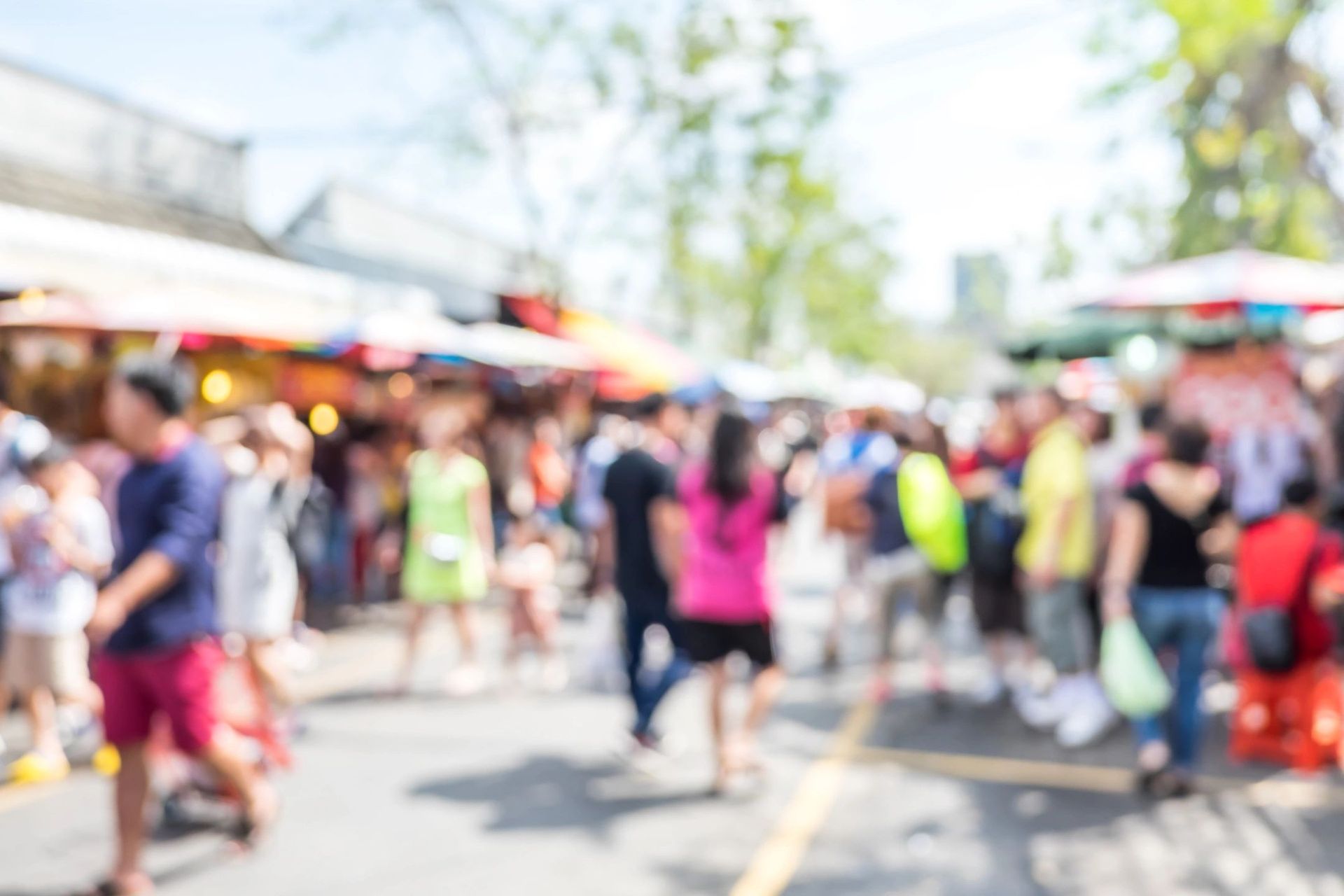A blurry picture of a crowd of people walking down a street.