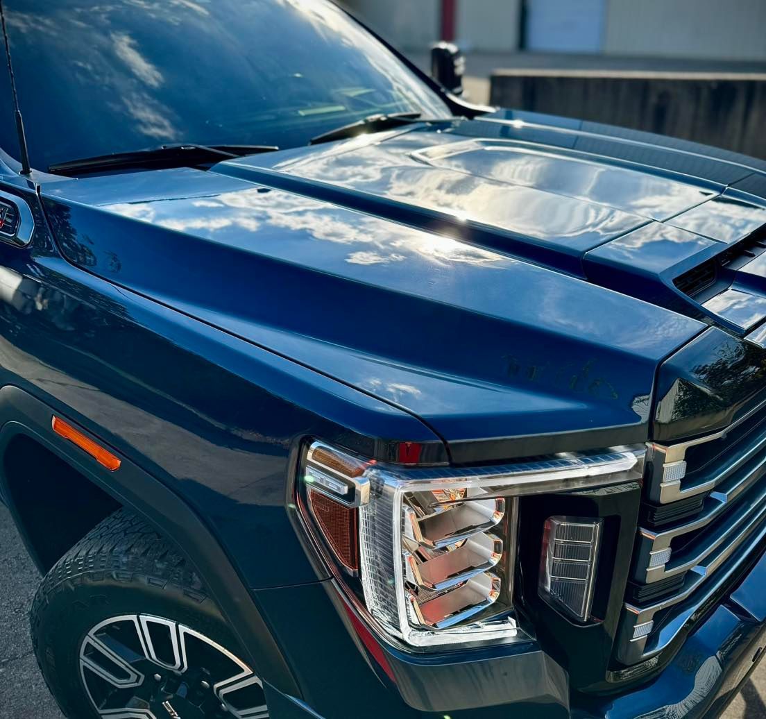 A blue truck is parked on the side of the road.