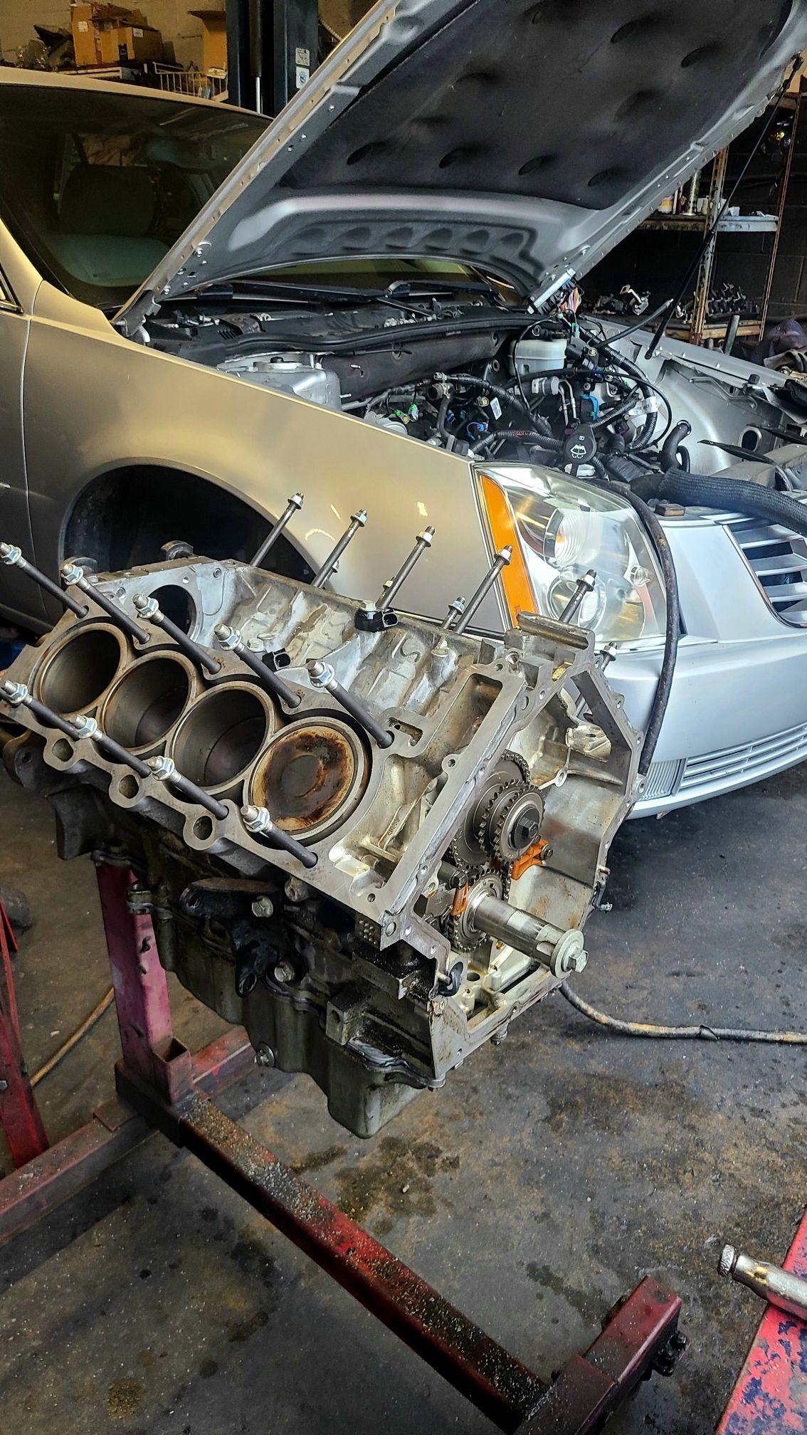 A car engine is being removed from a car in a garage.