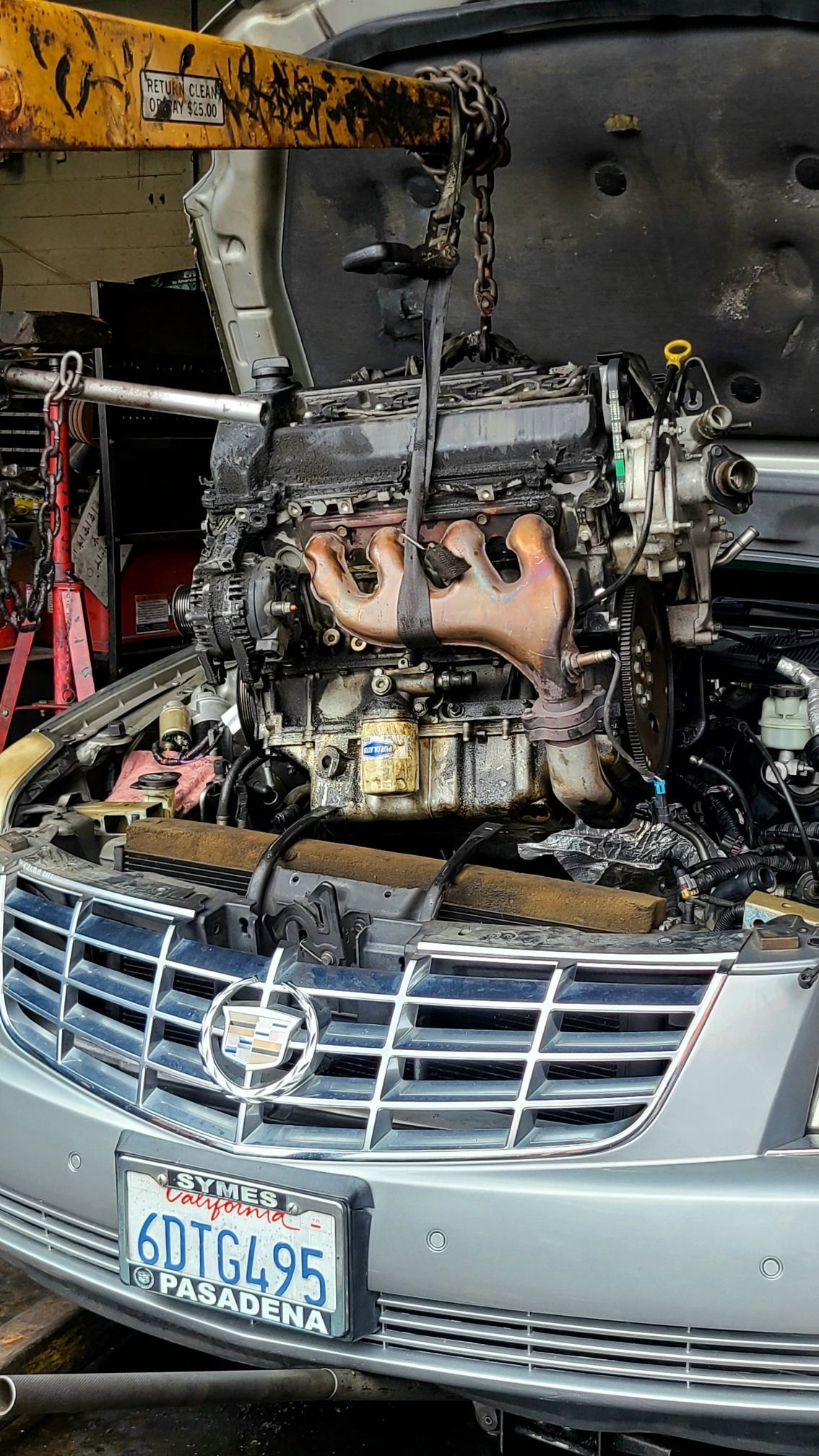 The engine of a car is being removed from the car.