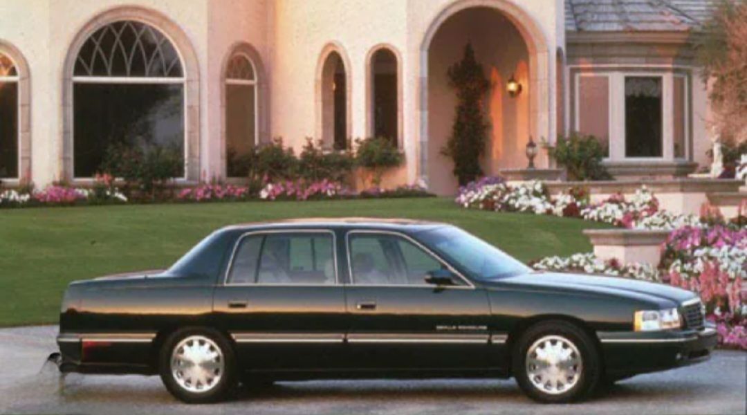 A black car is parked in front of a house