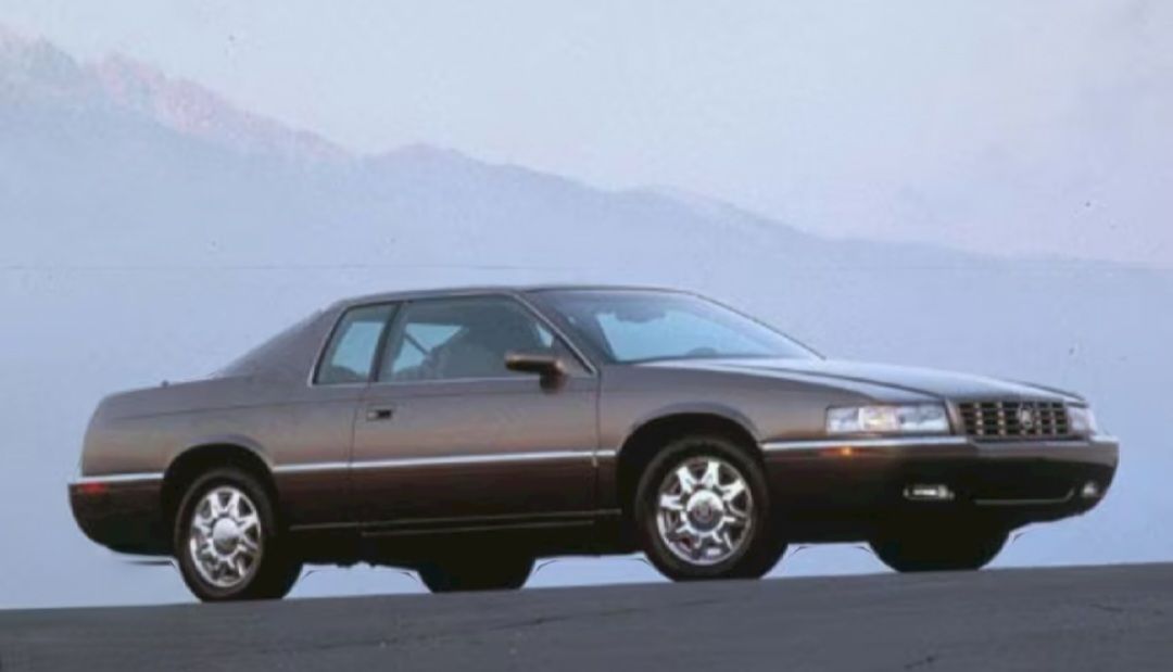 A silver car is parked on the side of a road