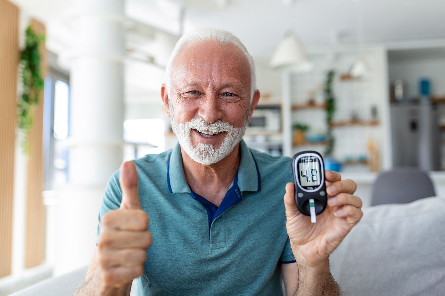 Happy senior man holding a glucose meter