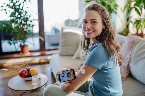 Happy woman showing her glucose level