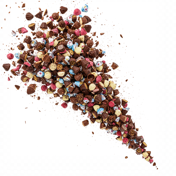 Pezzi di cioccolato fondente e colorato che esplodono su uno sfondo bianco.