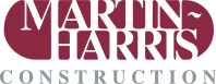 Logo for Martin Harris Construction: Text in white over a burgundy oval, 