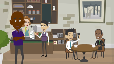 People in a coffee shop: two men at a table, barista, another man looking at the camera, others.