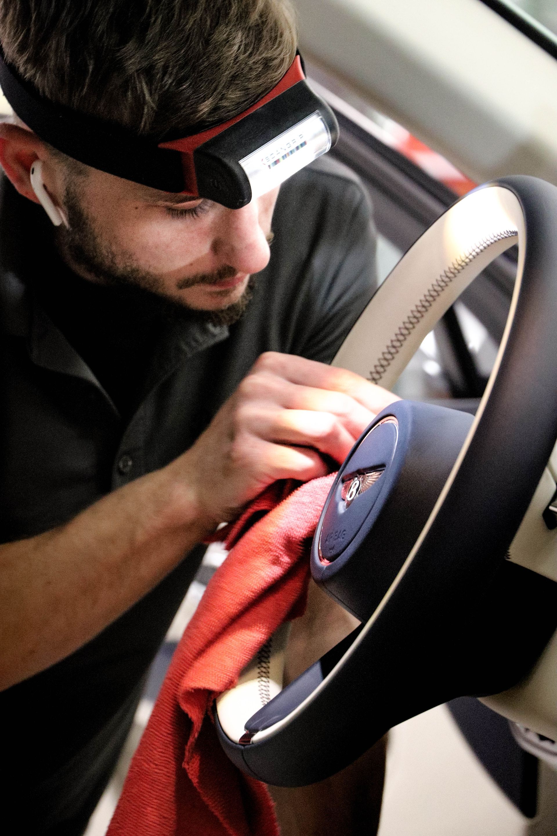 A man is cleaning the steering wheel of a car