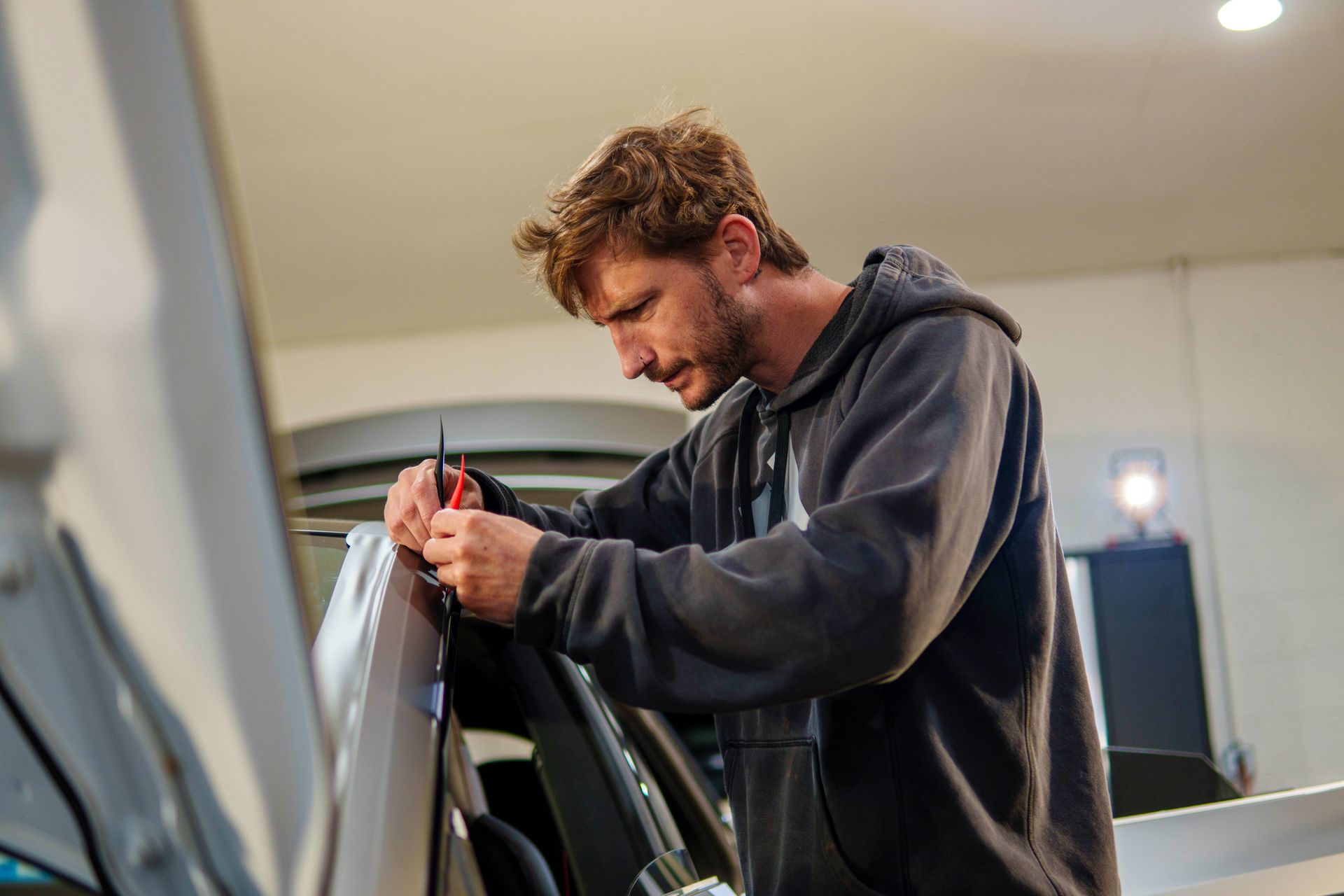A man is working on a car in a garage.