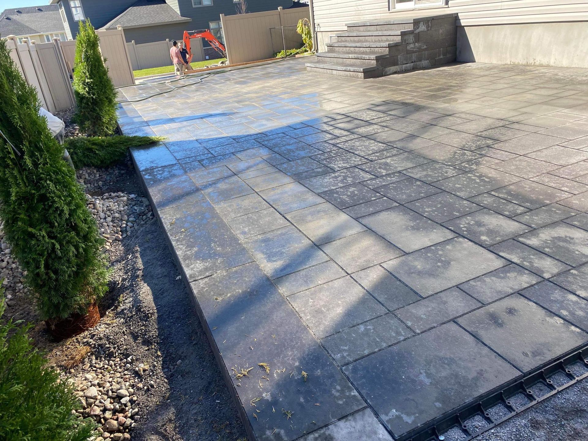 Une passerelle en brique est en cours de construction devant une maison.