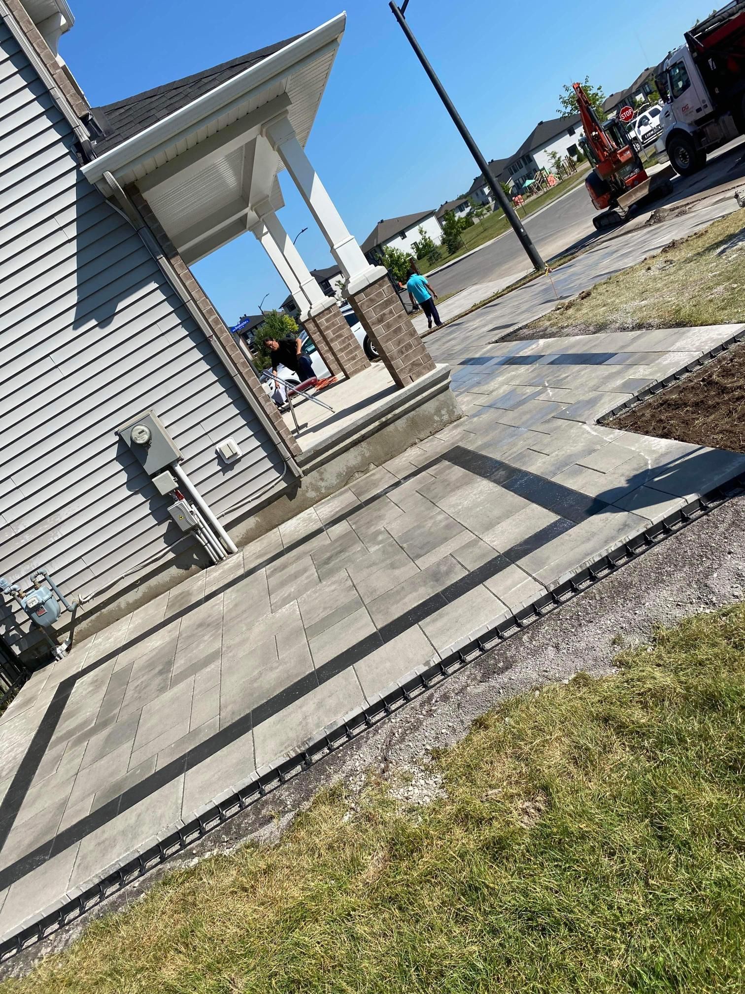 Un trottoir est en construction devant une maison.