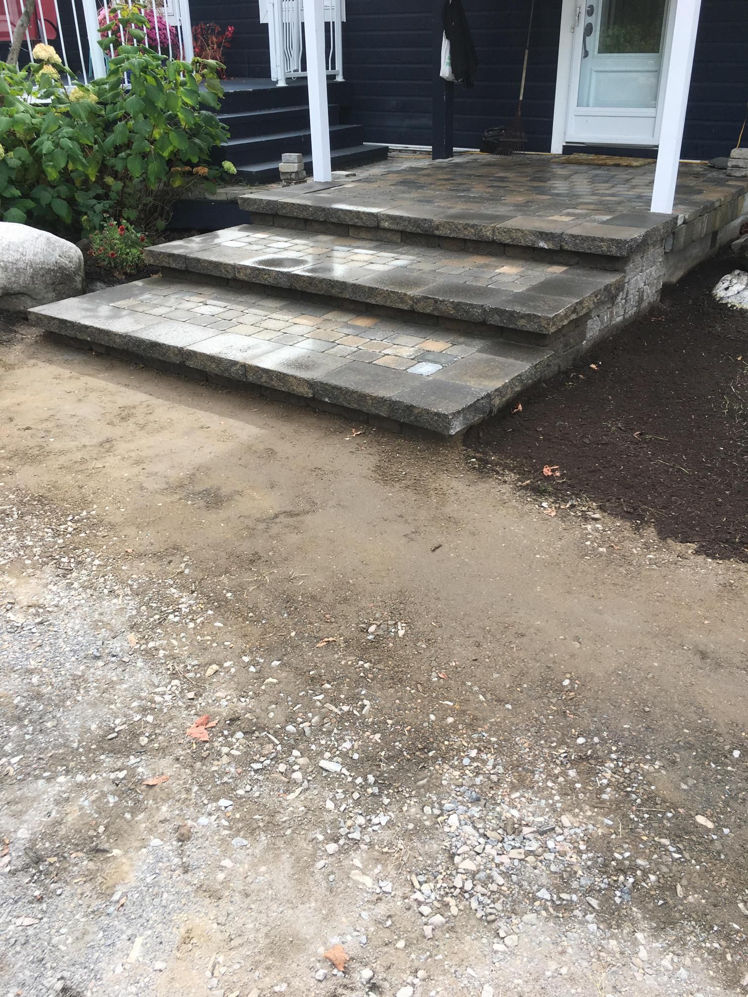 Un ensemble de marches en béton menant à un porche d'une maison.
