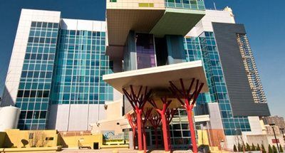 Modern building with glass walls, multiple colorful blocks, and a red-legged canopy.