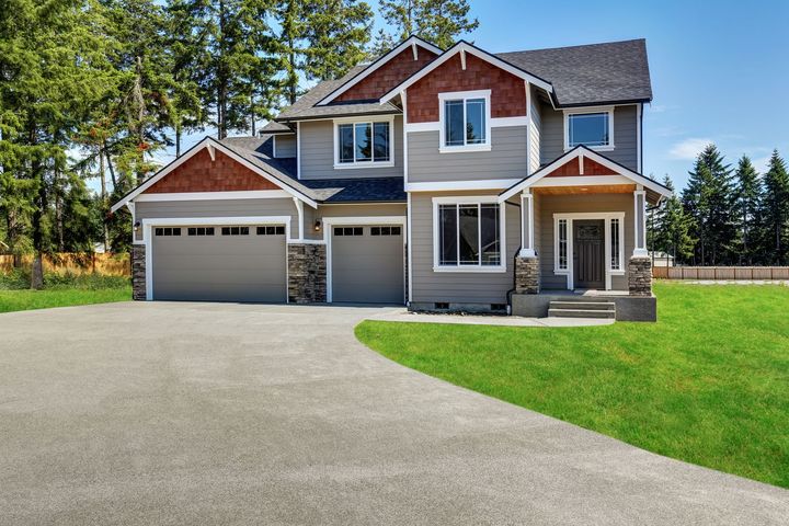 2 story house with a long straight concrete driveway at the front.