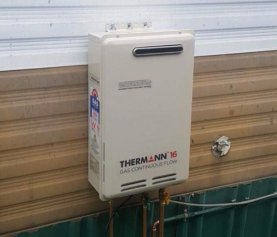 Comparison of an Old Rusty Water Heater and a New White Water Heater — Hunter Plumbing And Hotwater in Raymond Terrace, NSW