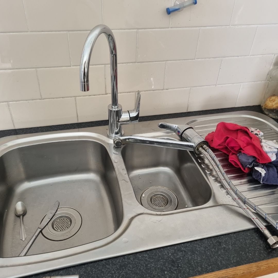 Stainless Steel Kitchen Sink With Faucet and Discarded Plumbing Parts — Hunter Plumbing And Hotwater in Billinudgel, NSW