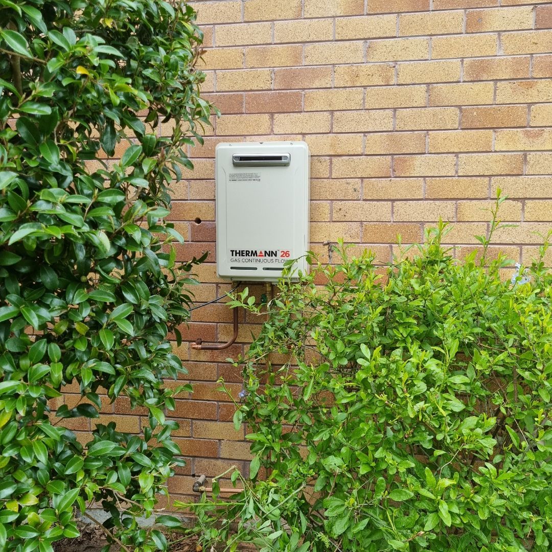 Cream-colored Gas Heater Box on a Brick Wall — Hunter Plumbing And Hotwater in Lemon Tree Passage, NSW