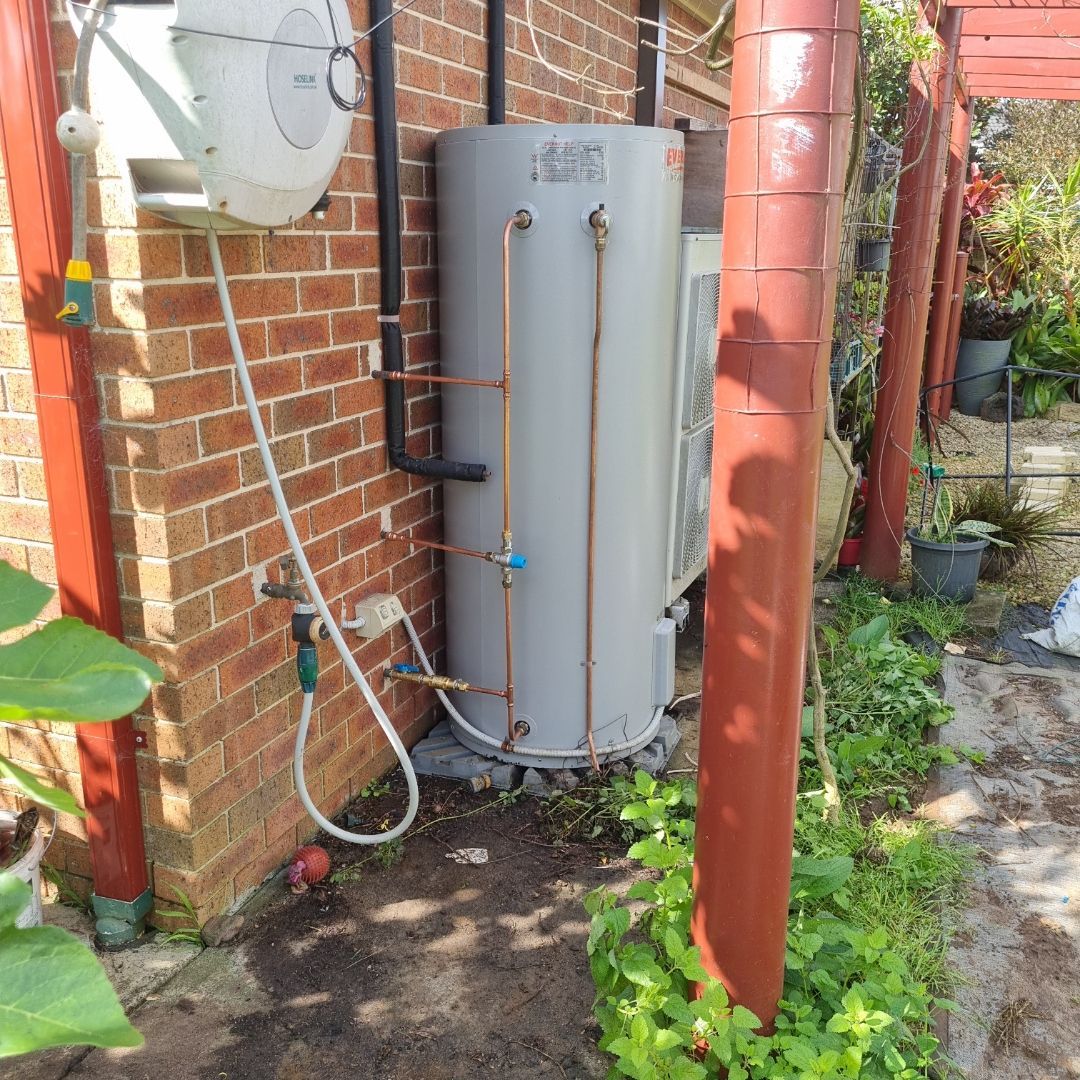 A Hot Water System Mounted on a Brick Wall — Hunter Plumbing And Hotwater in Tanilba Bay, NSW