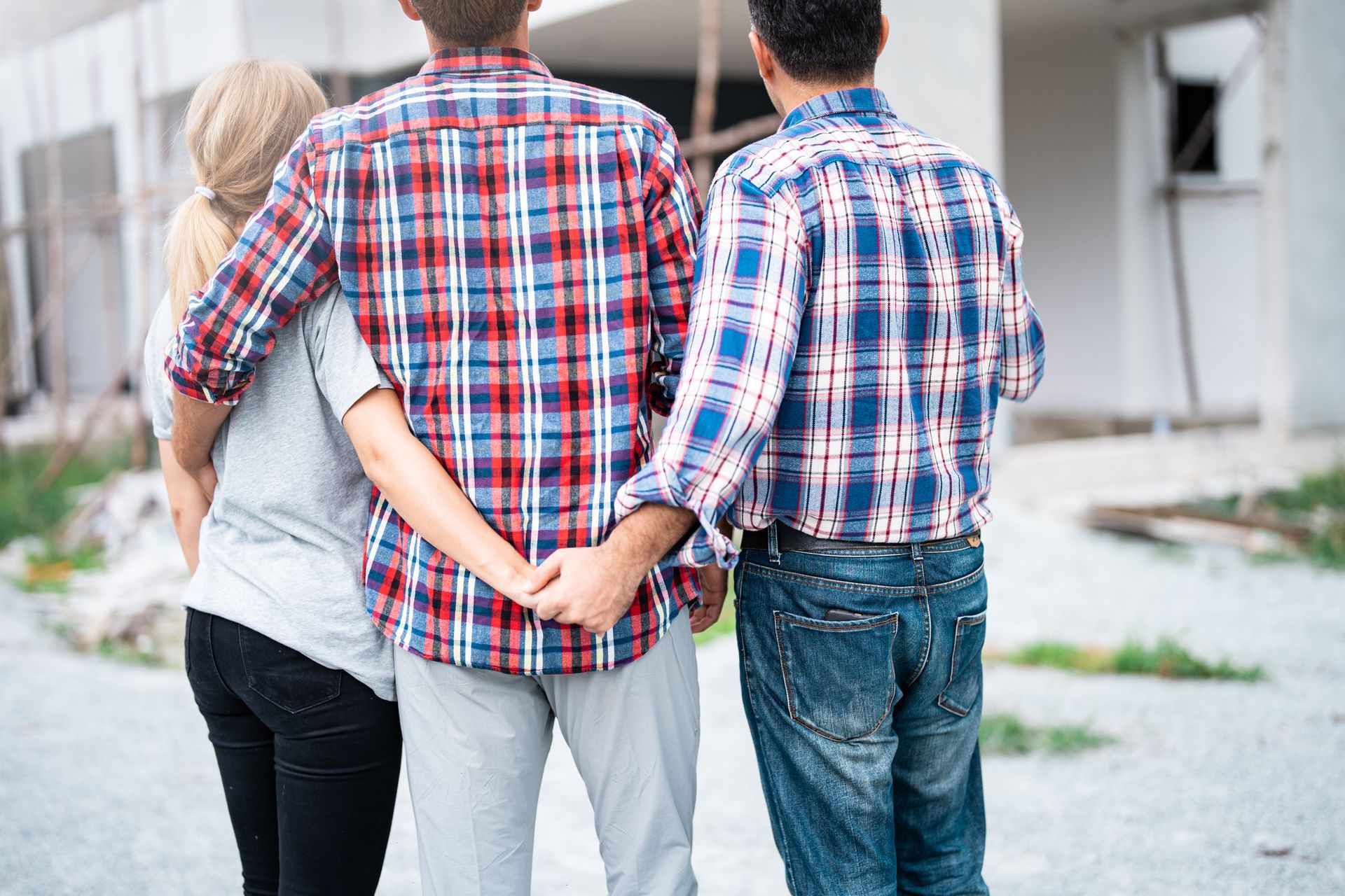 A wooden house and stacks of coins on a table.