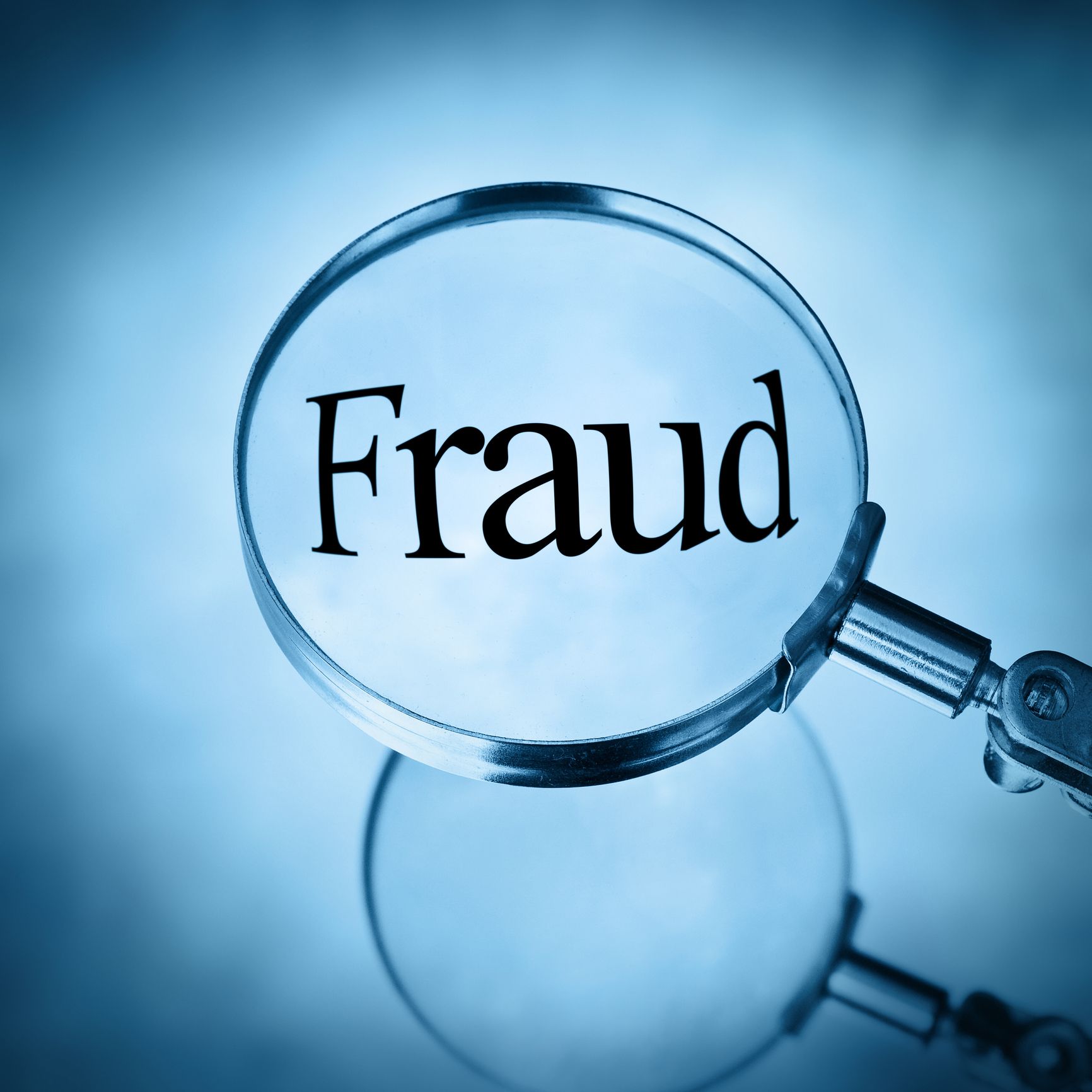 Magnifying glass with the word fraud magnified in blue tone.