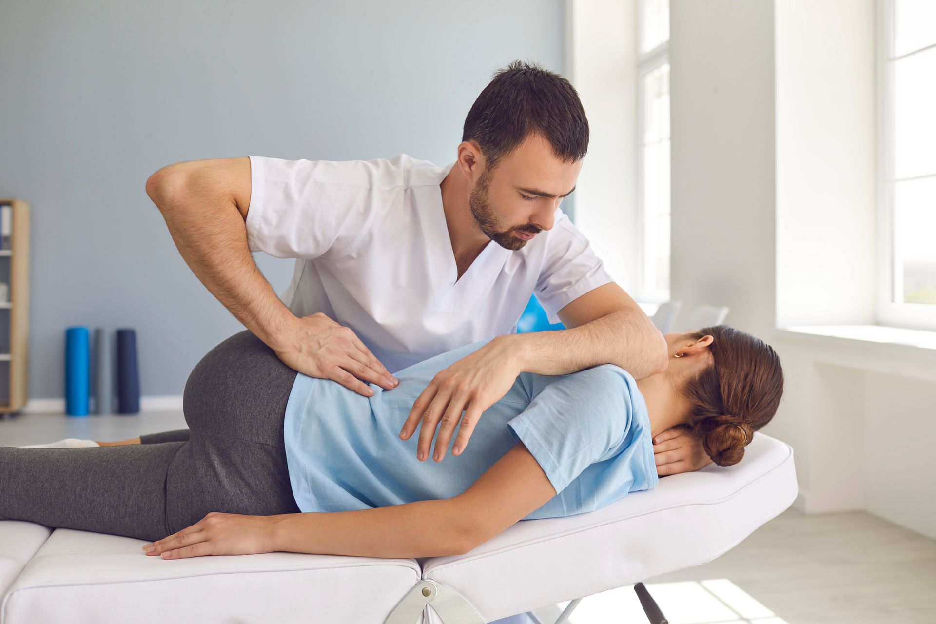 A man is giving a woman a massage on a table.