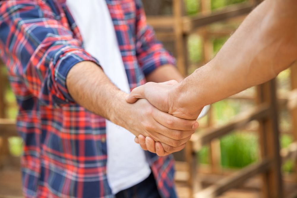 Roofer shaking hands with client — Qualified Roofer in Canberra