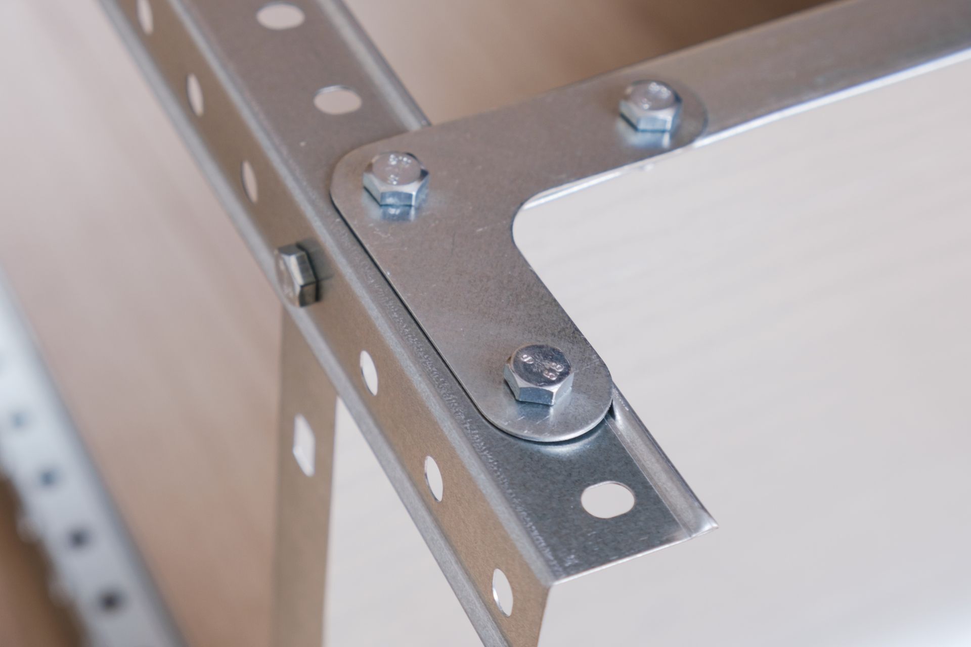 Close-up of a metal L-shaped corner steel bracket for fixing parts of a prefabricated structure.