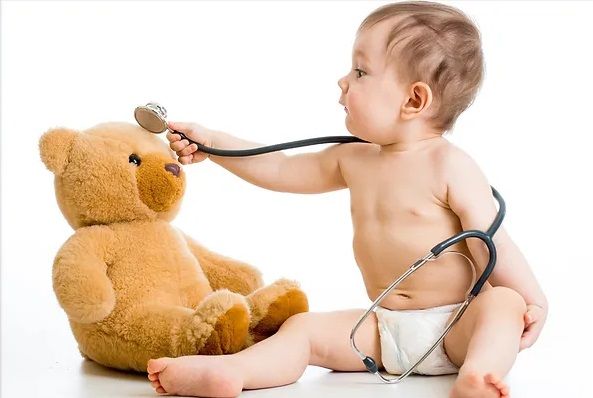 Baby in a diaper with a stethoscope listening to a teddy bear's heart