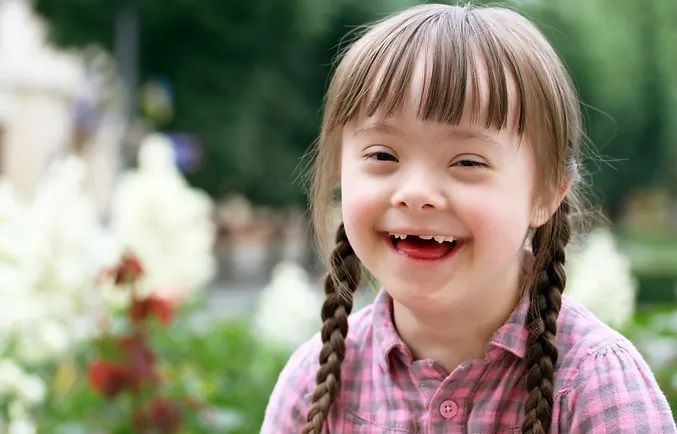 A little girl with braids is smiling for the camera.