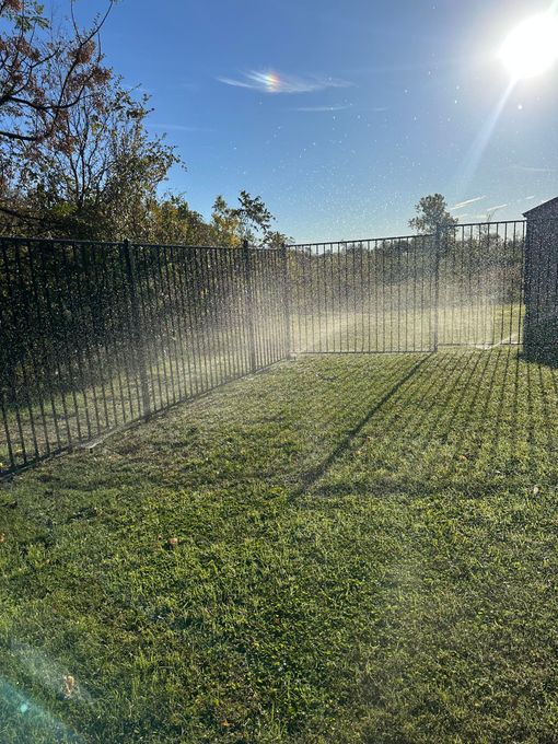 A sprinkler is spraying water on a lush green lawn.
