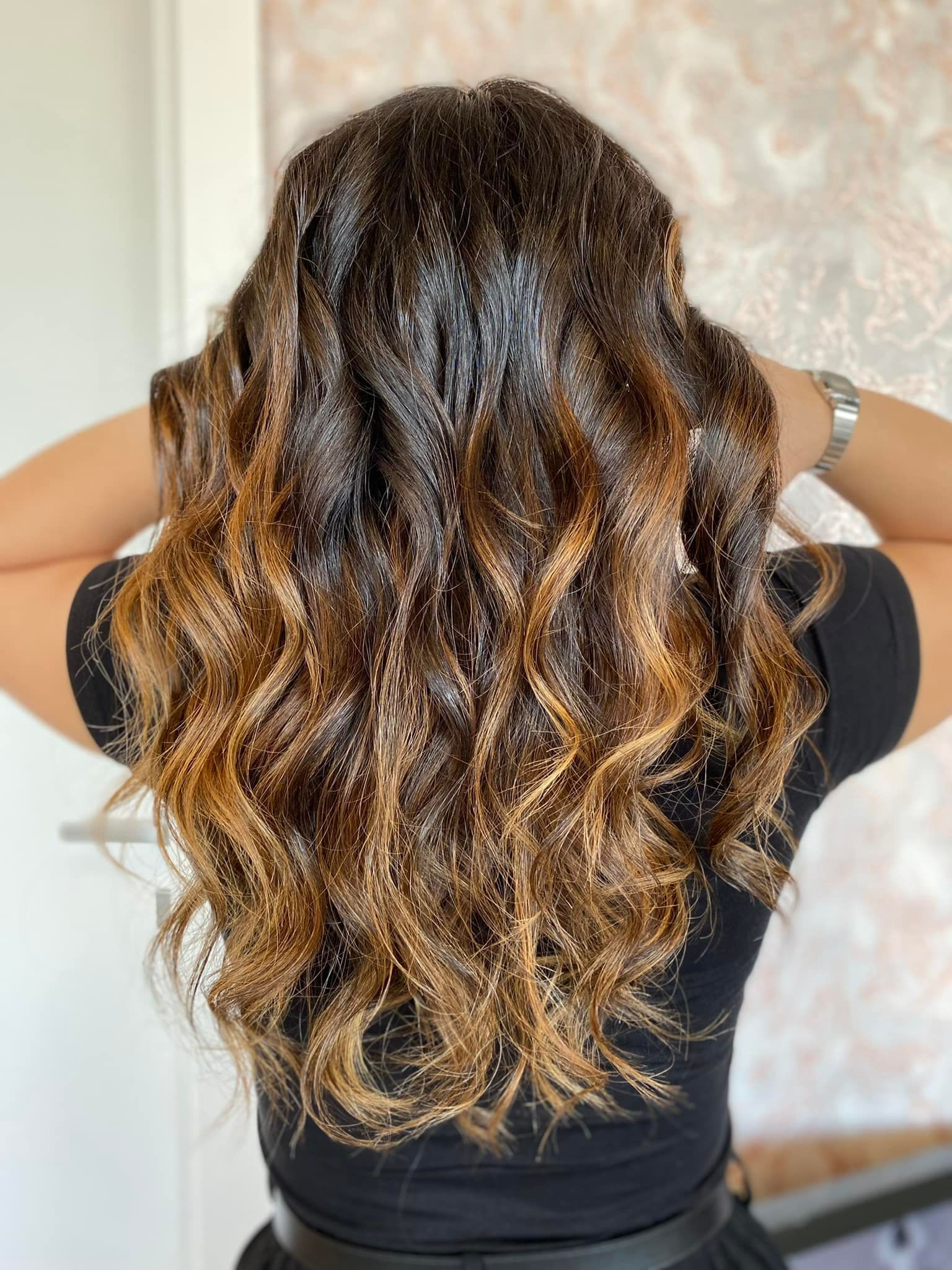 La parte posteriore della testa di una donna con lunghi capelli ricci.