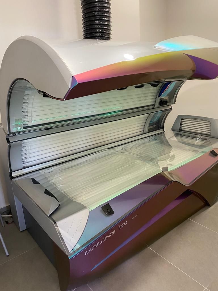 Un lettino abbronzante è posizionato su un pavimento piastrellato in una stanza.