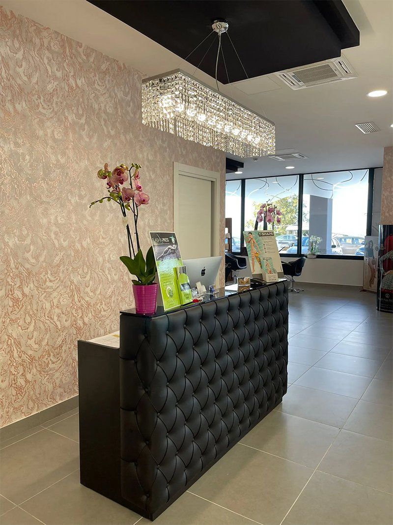 Un bancone della reception in una stanza con un lampadario appeso al soffitto.