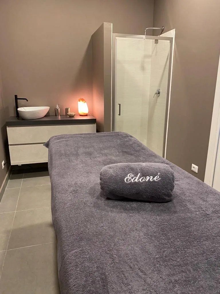 Un lettino da massaggio con un asciugamano sopra in un bagno.