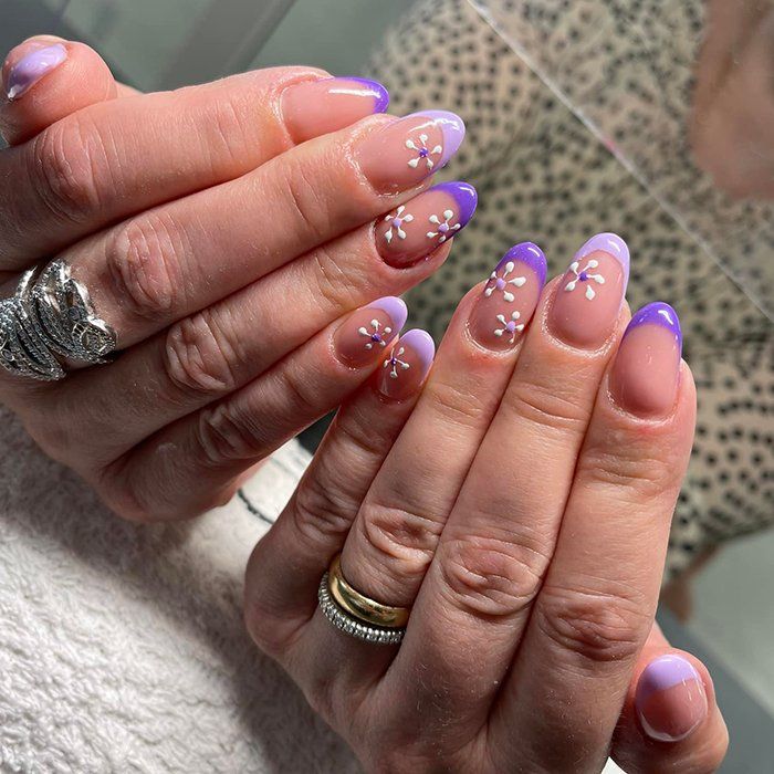 Un primo piano delle unghie di una donna con un anello al dito.