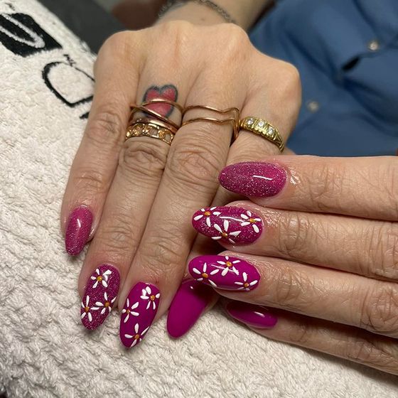Un primo piano delle unghie di una donna con dei fiori sopra