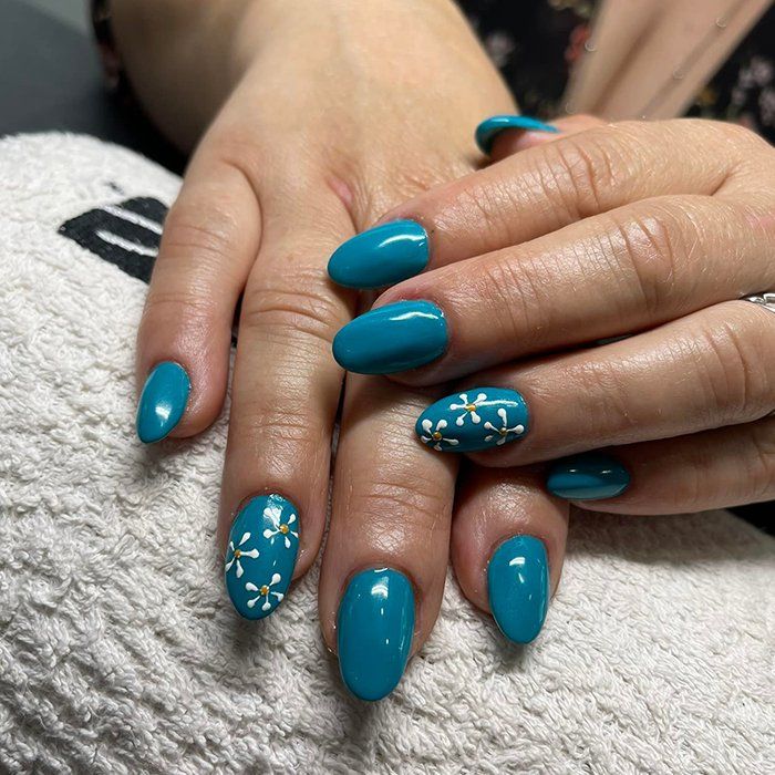 Un primo piano delle mani di una donna con le unghie blu