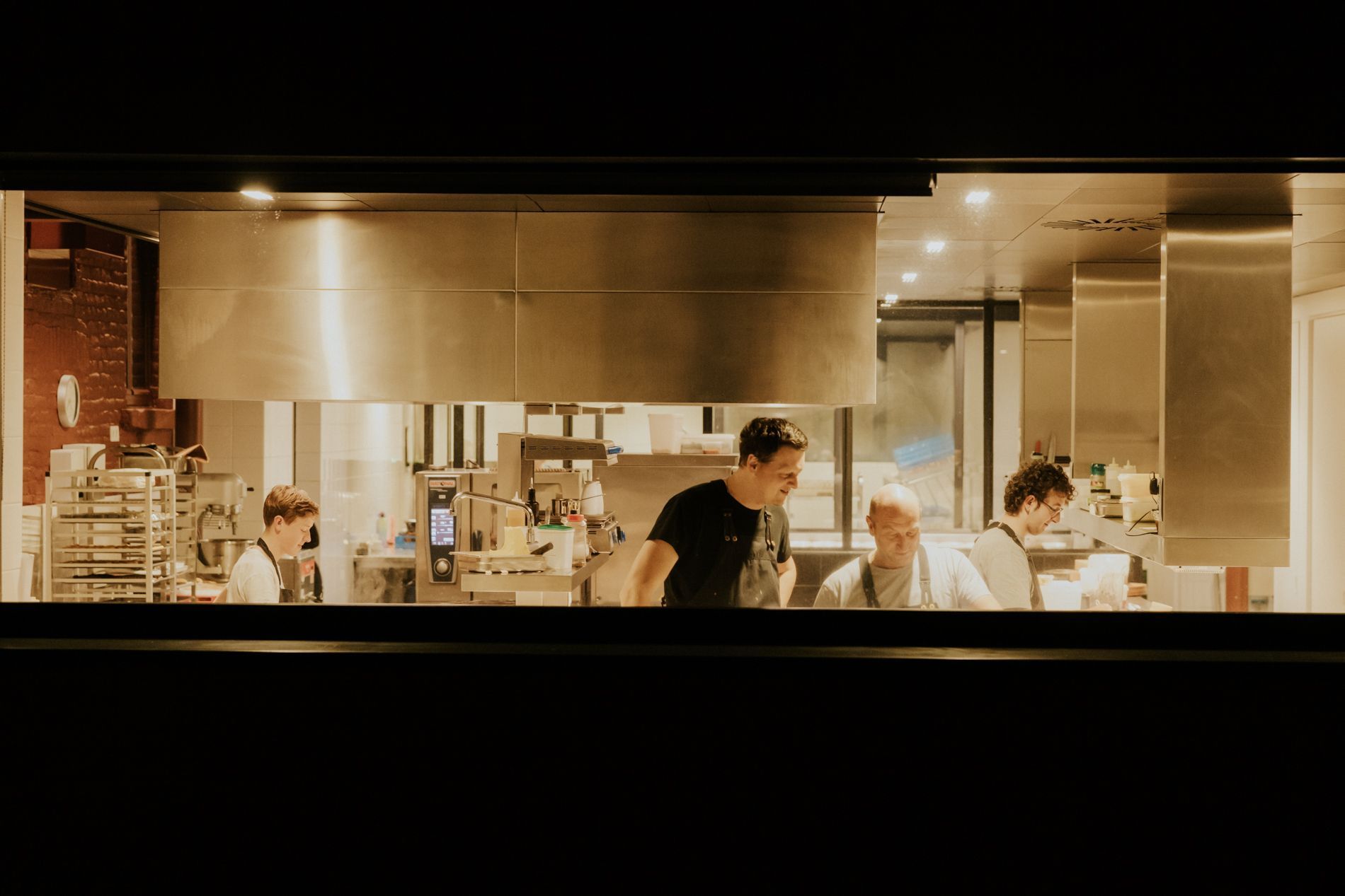 Het keukenpersoneel die staat te werken in de keuken.