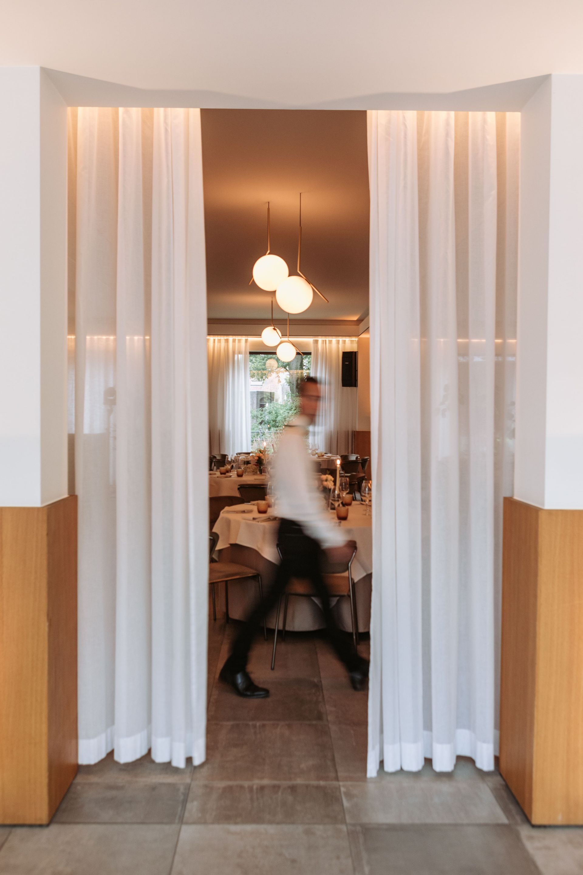 Een man loopt door een deuropening van een feestzaal. Feestzaal t'Hoornaerts te Izegem.